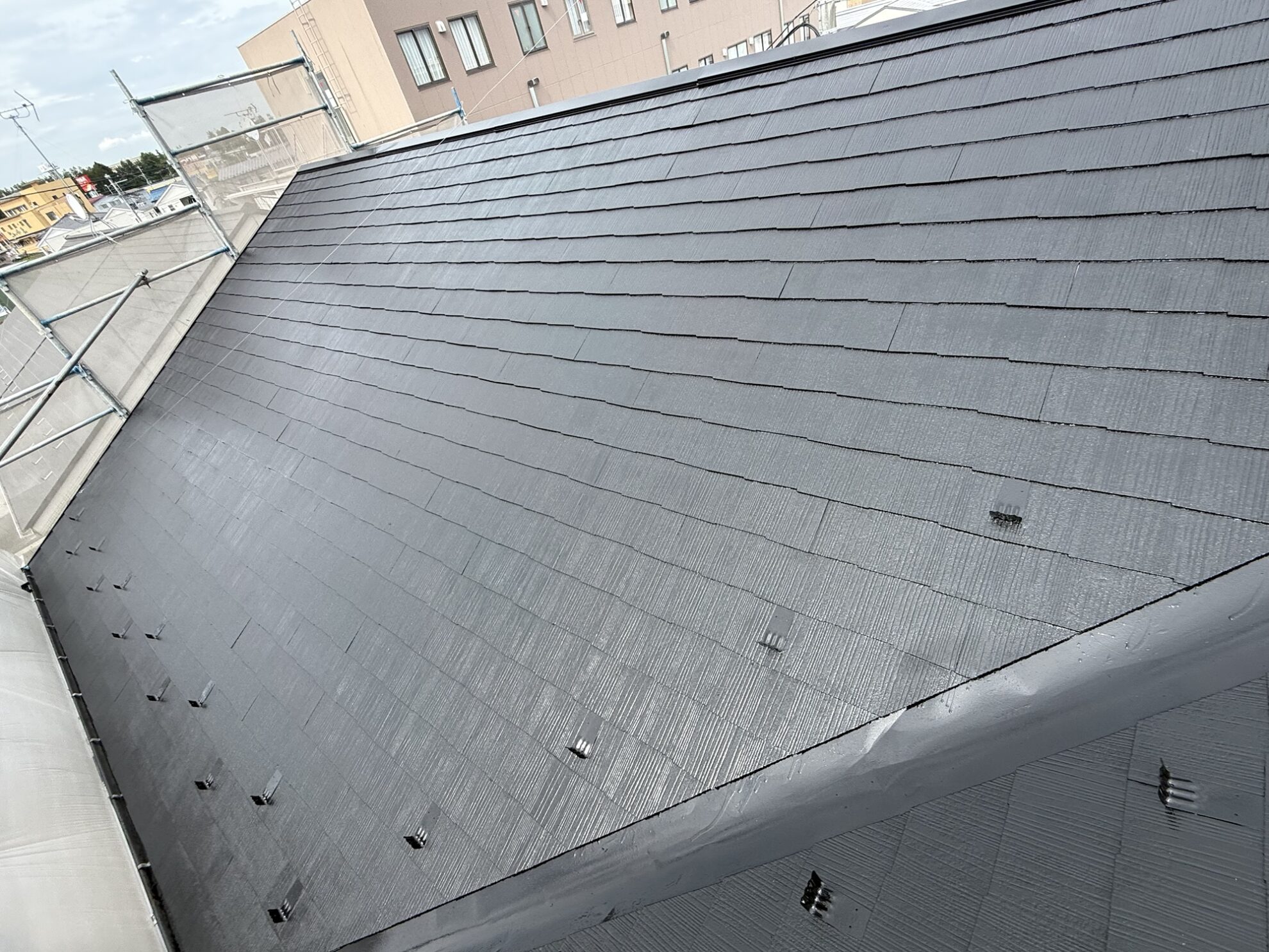 中塗りが完了し、色が均一に整った多賀城市のアパート屋根。上塗り前でも艶やかに仕上がっています