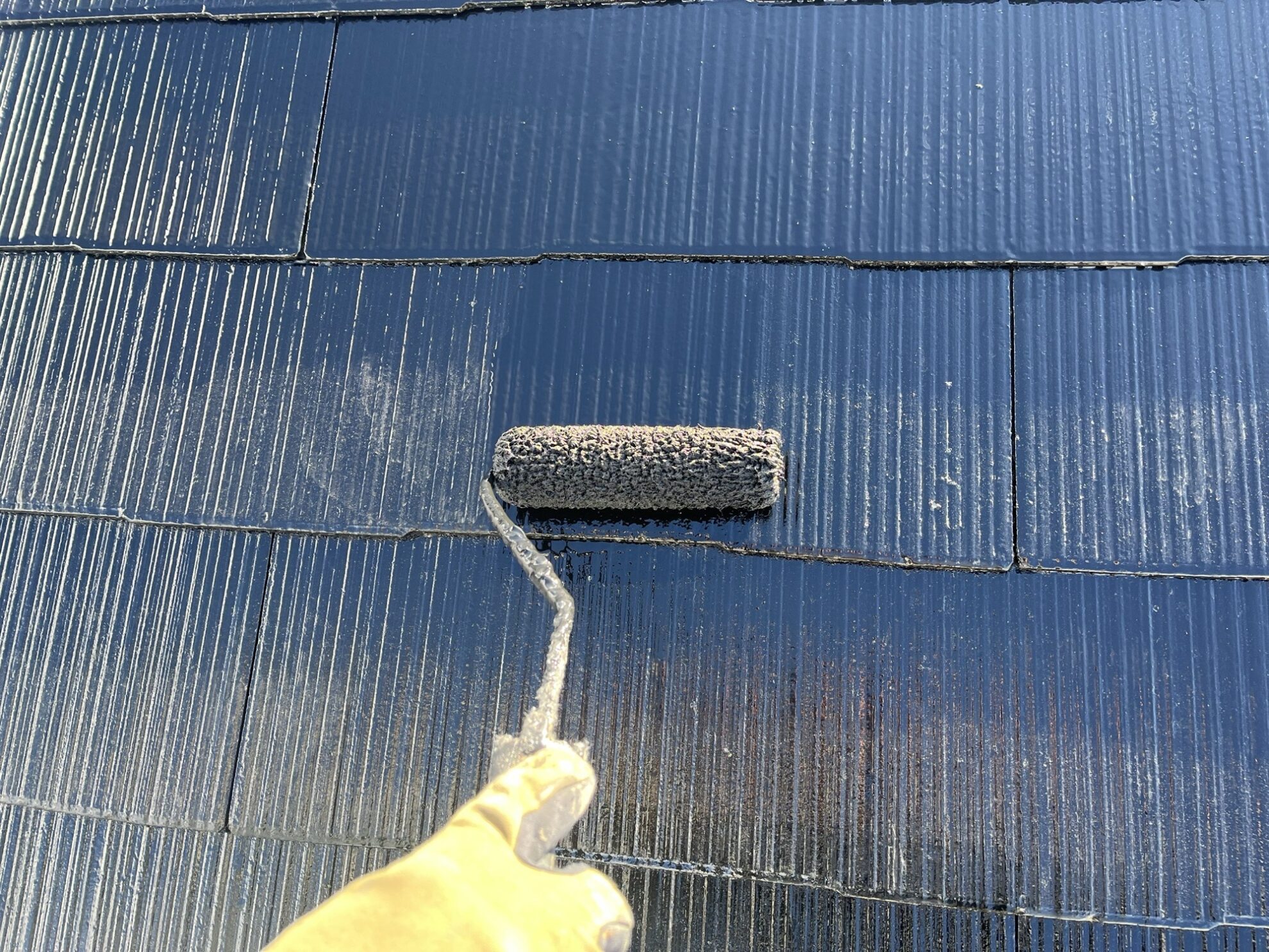 仙台市太白区アパートの屋根上塗り施工中②|細部まで丁寧に塗料を塗布している様子