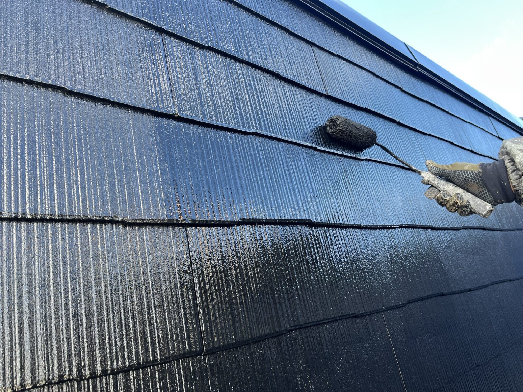 仙台市太白区アパートの屋根上塗り施工中①|ラジカルハイブリッドシリコン塗料をムラなく塗布している様子