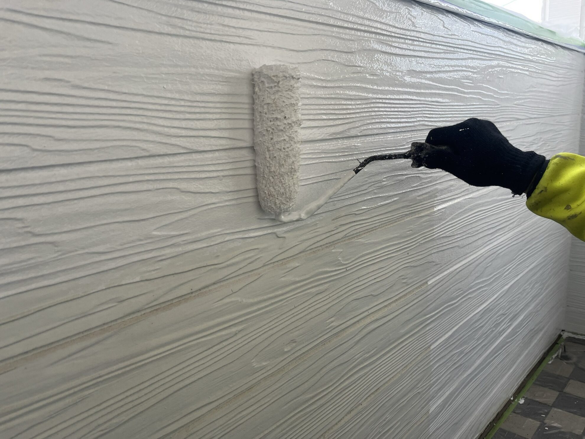 仙台市太白区 アパート外壁塗装 ローラーで均一に中塗り塗布の様子