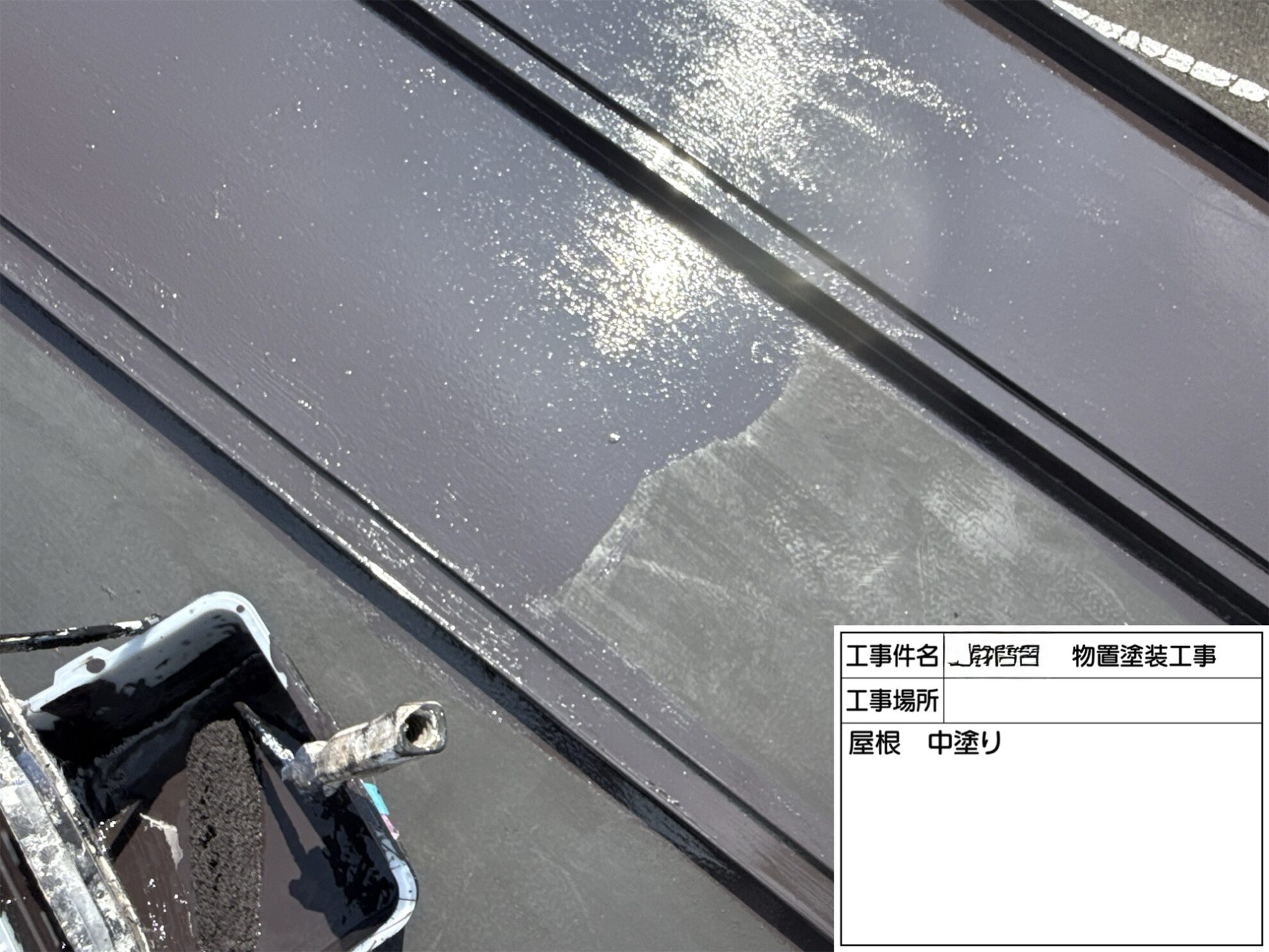 塩竈市の物置金属屋根に仕上げ塗料を中塗りしている様子