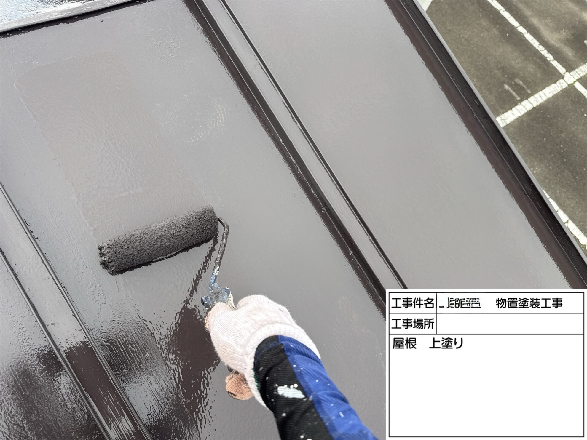 塩竈市の物置金属屋根をローラーで上塗りしている様子